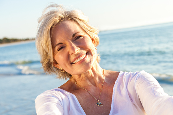Happy Senior Woman Smiling On The Beach After having Dental crown in Ponte Vedra, FL